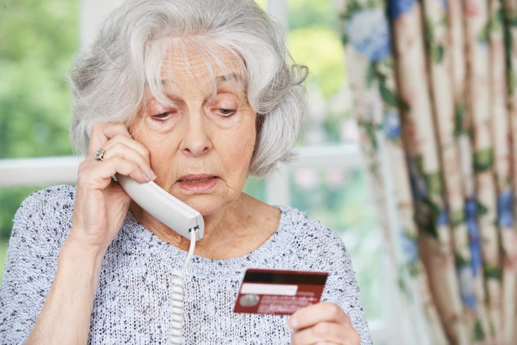 starsza kobieta rozmawiająca przez telefon - objawy demencji